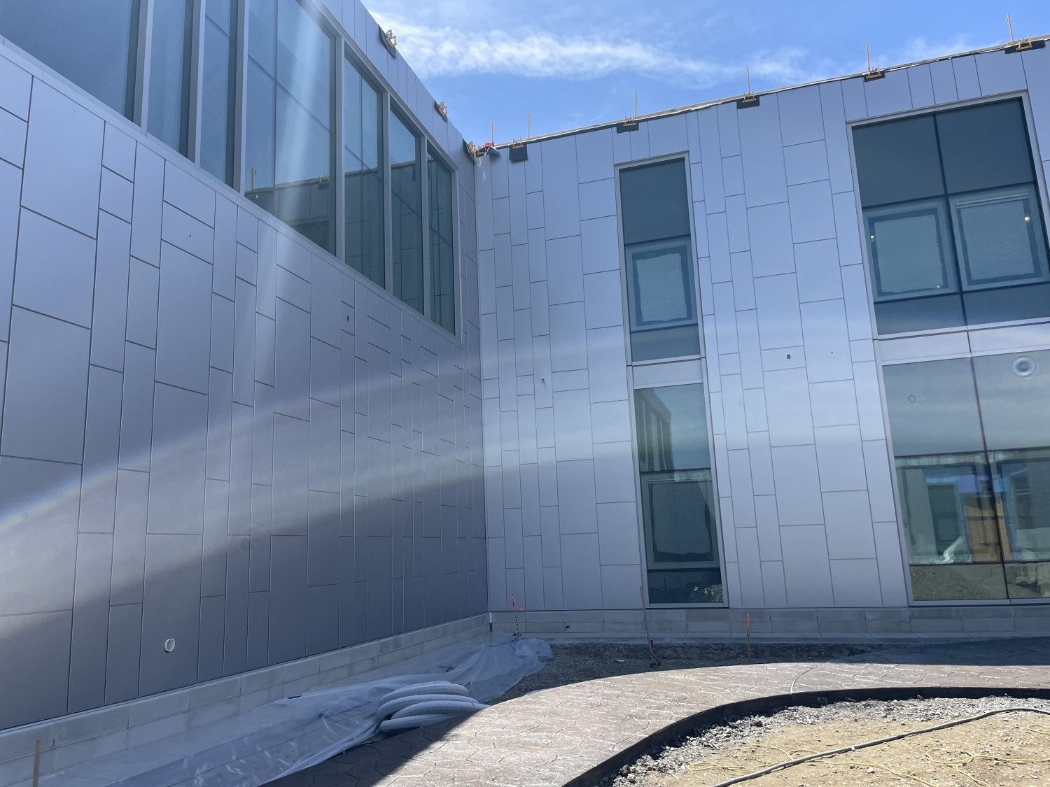 CLADLOK™ panels — silver aluminum cassette panels on commercial building courtyard